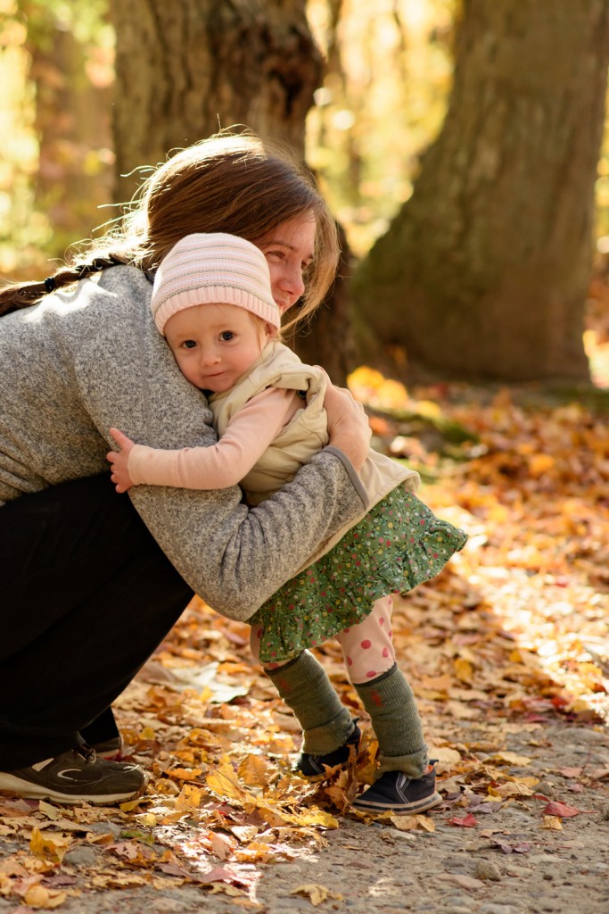 Toddler hugging mother in fall woods. Family portrait photography by Maryellen Malloy Photography.